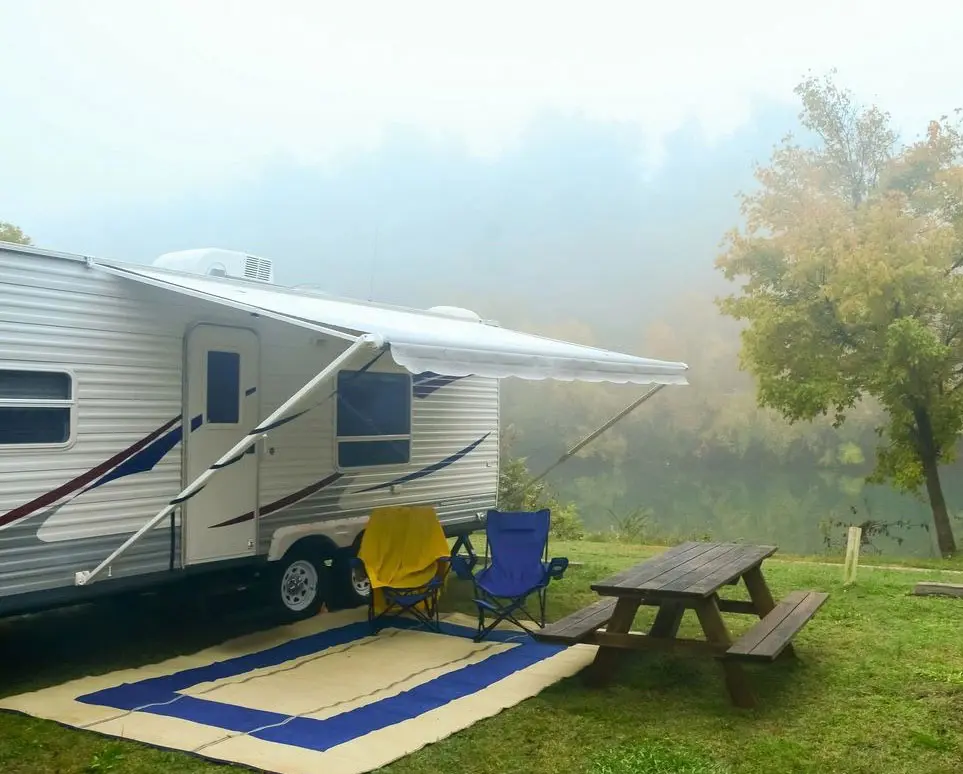 RV motor van near a lake with a rest chairs