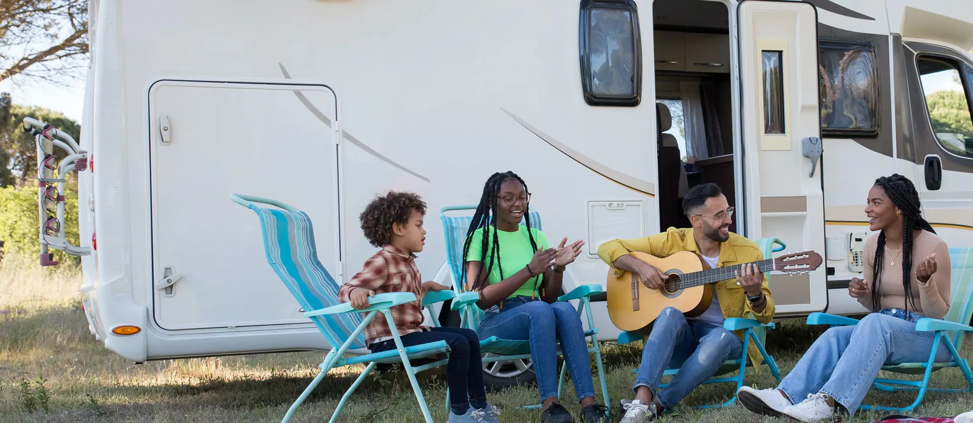 Group of people having outdoor party with playing guitar and singing